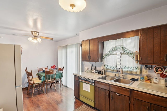 kitchen with dark wood-type flooring, sink, ceiling fan, dishwashing machine, and white fridge