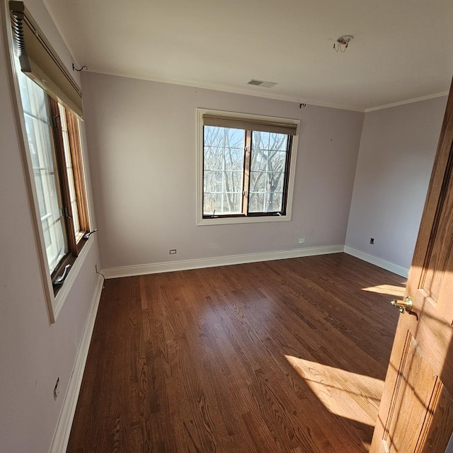 empty room with dark hardwood / wood-style floors and ornamental molding