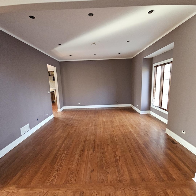 spare room featuring crown molding and hardwood / wood-style floors