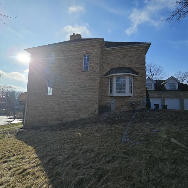 view of side of property featuring a garage and a water view