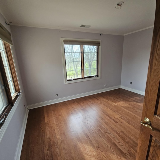 empty room featuring hardwood / wood-style floors and ornamental molding