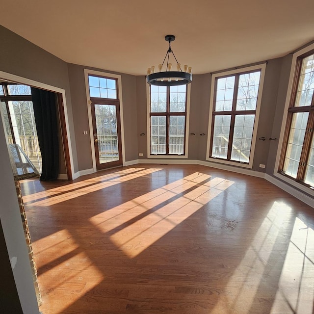 unfurnished dining area featuring hardwood / wood-style floors and a notable chandelier