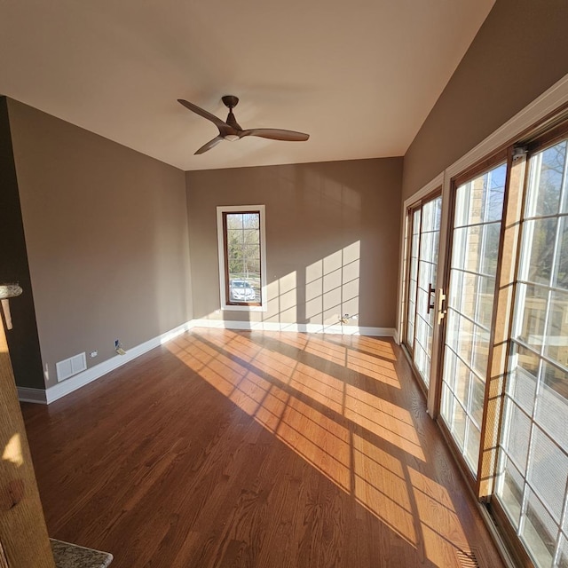 unfurnished room with ceiling fan, french doors, and dark wood-type flooring