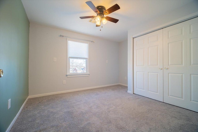 unfurnished bedroom featuring ceiling fan, a closet, and carpet