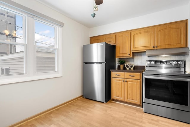 kitchen featuring decorative backsplash, light hardwood / wood-style flooring, ceiling fan, and appliances with stainless steel finishes