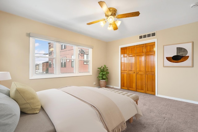 carpeted bedroom with ceiling fan and a closet