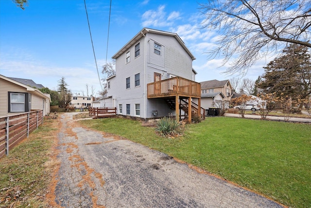 rear view of house with a lawn and a deck