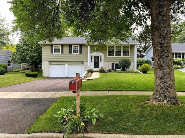 raised ranch featuring a front yard and a garage