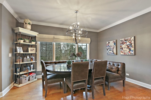 dining room featuring an inviting chandelier, hardwood / wood-style flooring, and ornamental molding