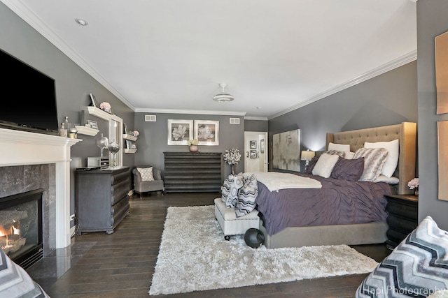 bedroom with a premium fireplace, dark wood-type flooring, and crown molding