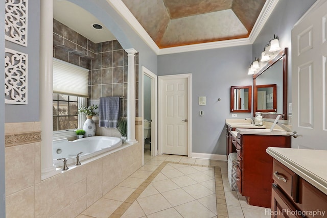 bathroom with tile patterned floors, ornamental molding, a raised ceiling, and ornate columns