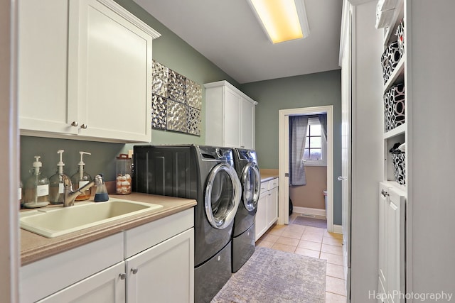 laundry room with independent washer and dryer, cabinets, sink, and light tile patterned floors