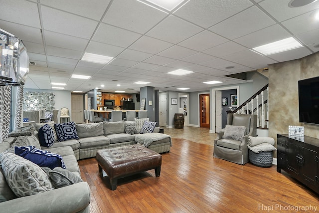 living room featuring hardwood / wood-style flooring and a drop ceiling