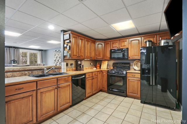 kitchen featuring light tile patterned floors, a paneled ceiling, sink, and black appliances