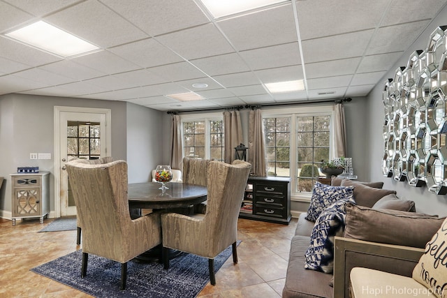 tiled dining area with a drop ceiling