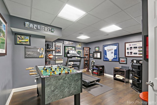 recreation room with a paneled ceiling and hardwood / wood-style floors