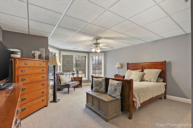 carpeted bedroom featuring a drop ceiling and ceiling fan