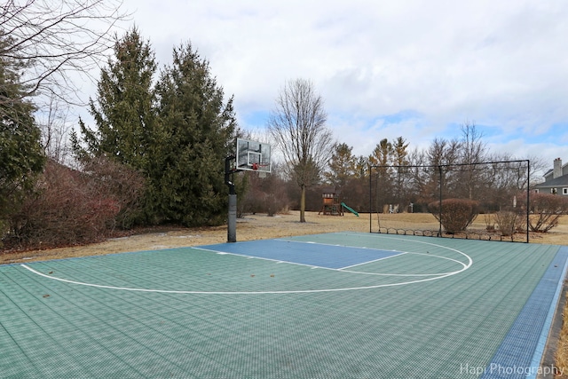 view of basketball court featuring a playground