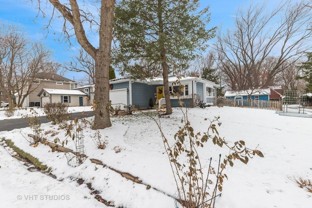 yard covered in snow featuring a garage