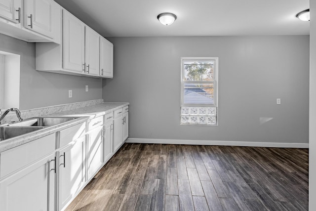 kitchen with dark wood-type flooring, sink, and white cabinets