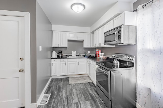 kitchen featuring sink, white cabinets, dark hardwood / wood-style floors, and stainless steel appliances