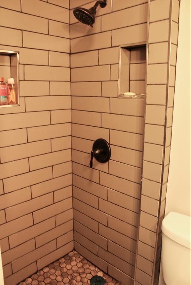 bathroom with toilet and tiled shower