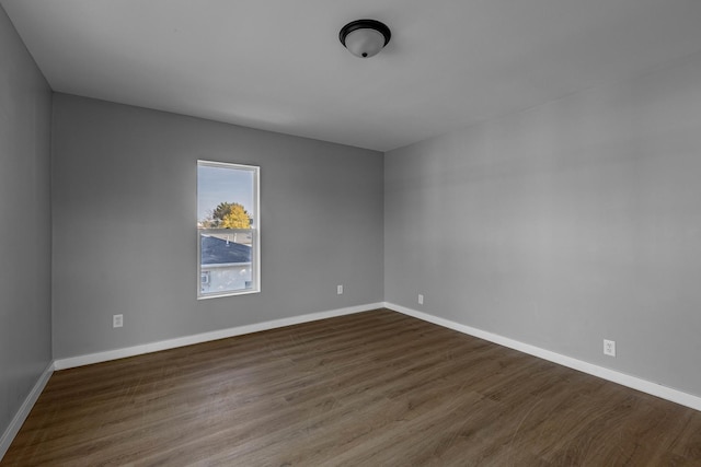 unfurnished room with dark wood-type flooring