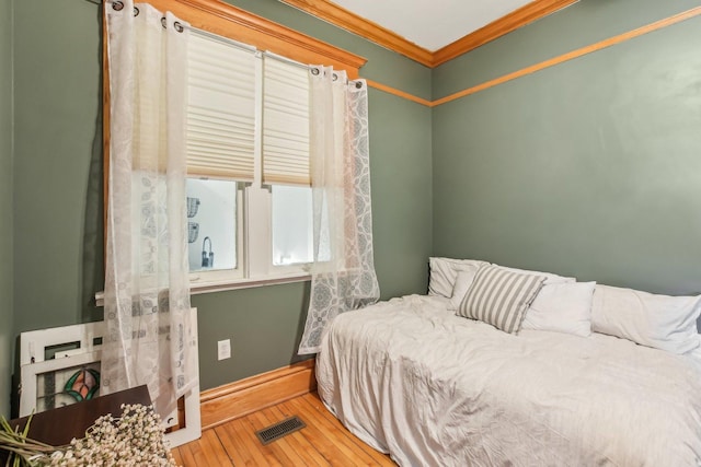 bedroom featuring crown molding and hardwood / wood-style flooring