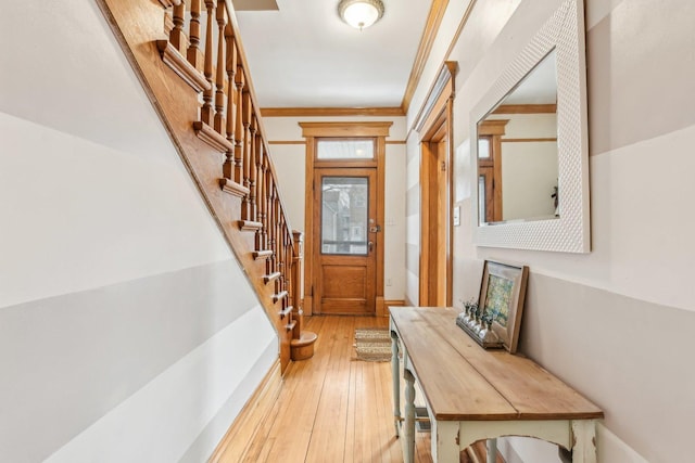 doorway featuring crown molding and light hardwood / wood-style flooring