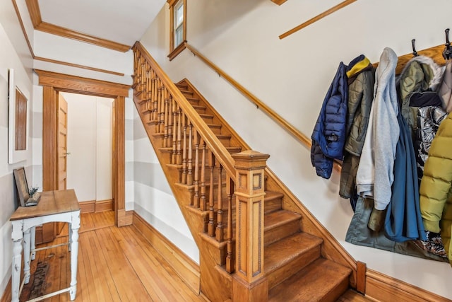 staircase featuring hardwood / wood-style flooring and crown molding