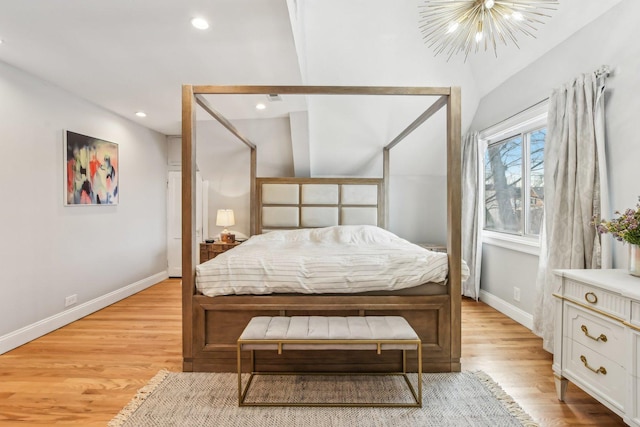 bedroom with vaulted ceiling, a chandelier, and light hardwood / wood-style flooring