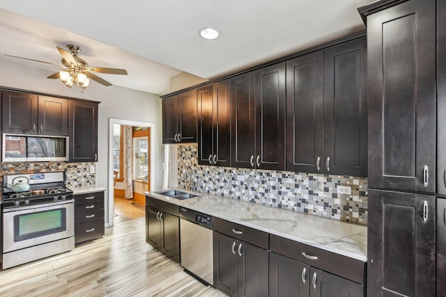 kitchen with backsplash, sink, light hardwood / wood-style flooring, dark brown cabinetry, and stainless steel appliances