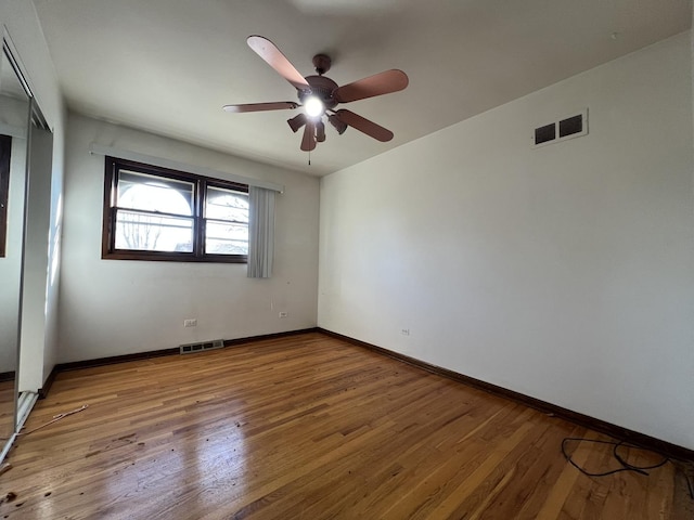 empty room with ceiling fan and wood-type flooring