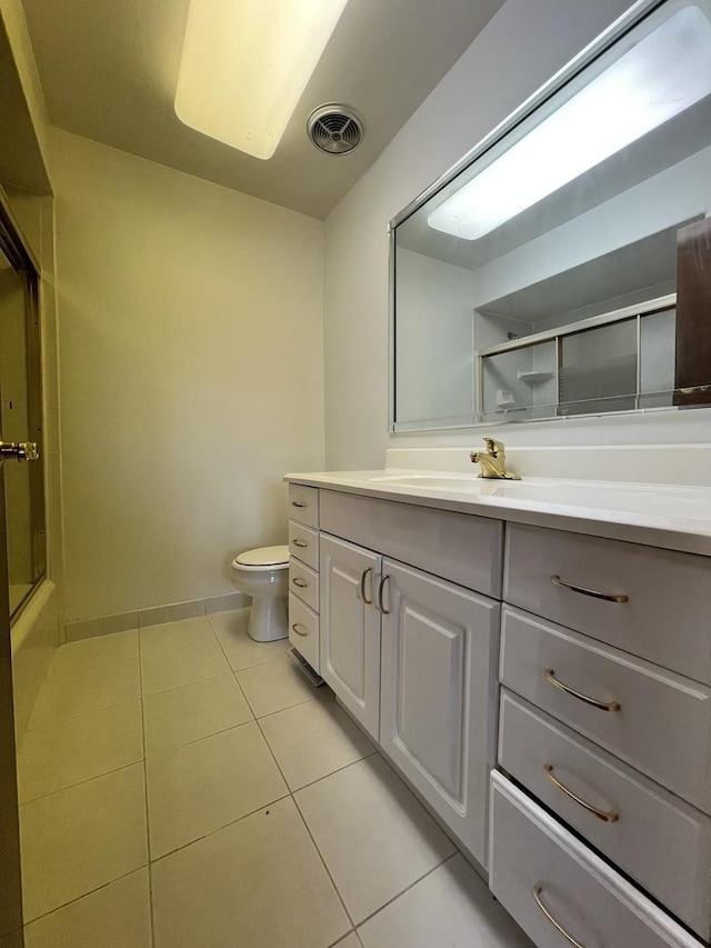 full bathroom featuring toilet, vanity, tile patterned floors, and combined bath / shower with glass door