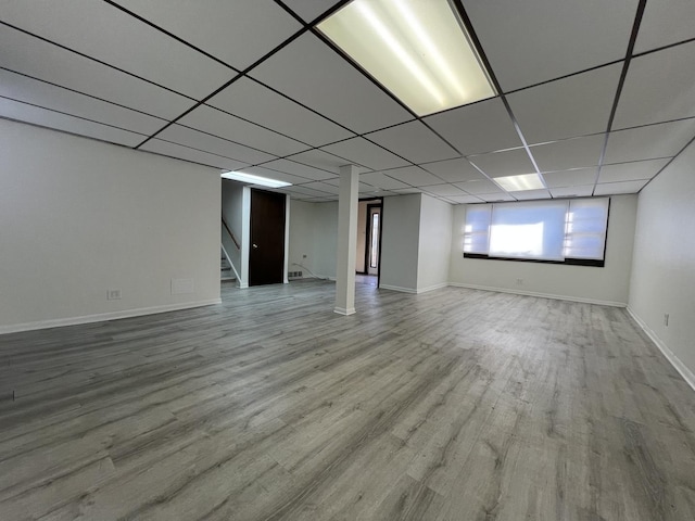 basement with a drop ceiling and wood-type flooring