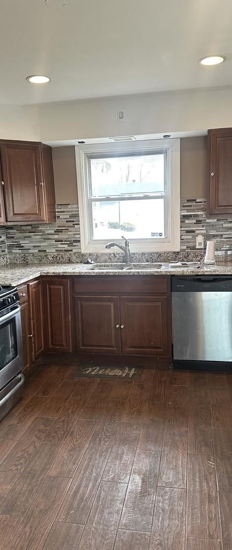 kitchen featuring backsplash, dark wood-type flooring, and appliances with stainless steel finishes