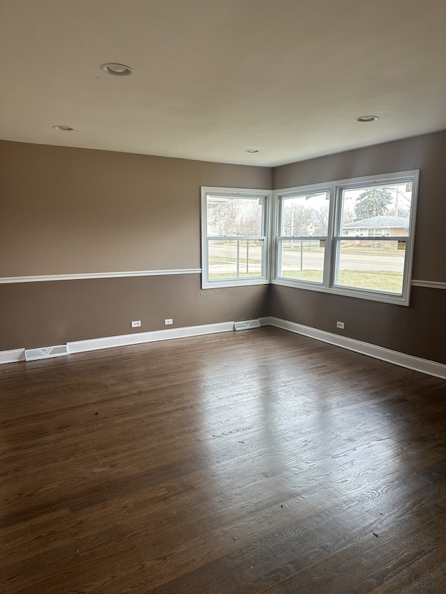 empty room featuring dark hardwood / wood-style flooring and plenty of natural light