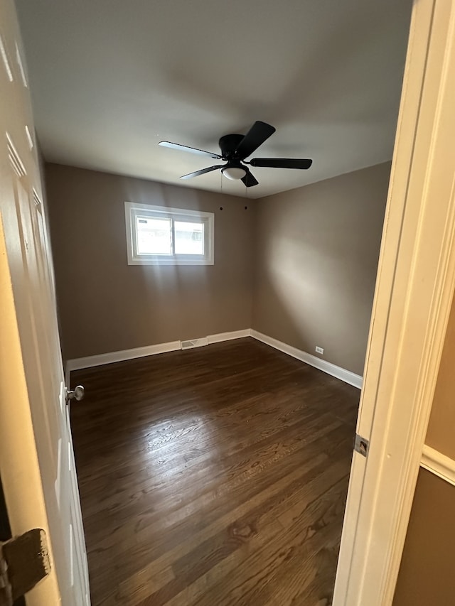 spare room with ceiling fan and dark wood-type flooring