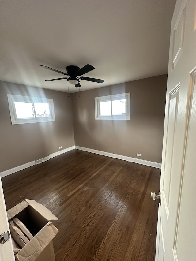 unfurnished room with ceiling fan, a healthy amount of sunlight, and dark hardwood / wood-style floors