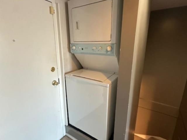 clothes washing area featuring stacked washer / dryer