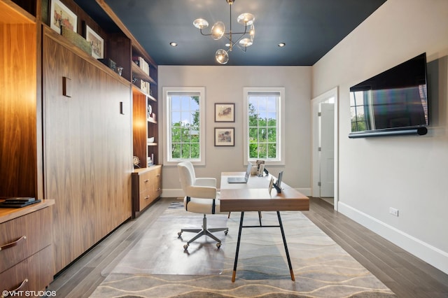 home office featuring a notable chandelier and light hardwood / wood-style flooring