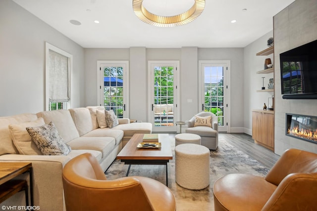 living room with a tile fireplace and light hardwood / wood-style floors