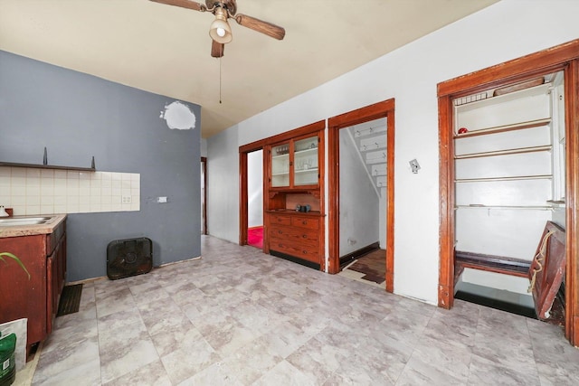 interior space with backsplash, ceiling fan, and sink