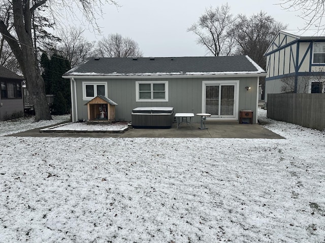 rear view of property with a patio area and a hot tub