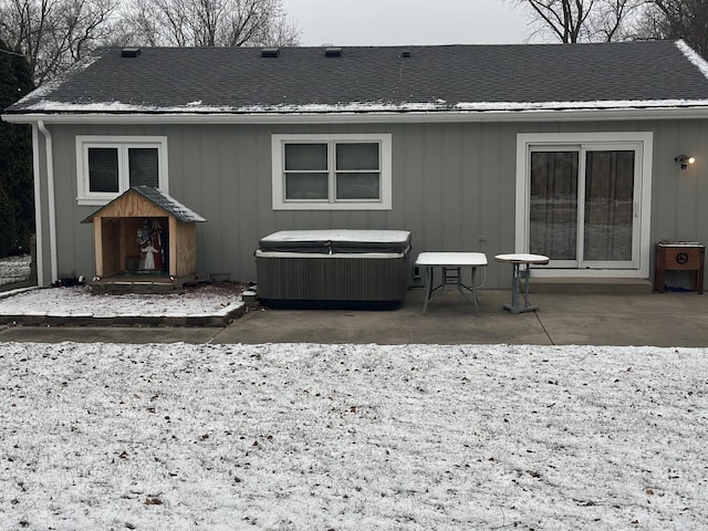 rear view of property with a patio area and a hot tub