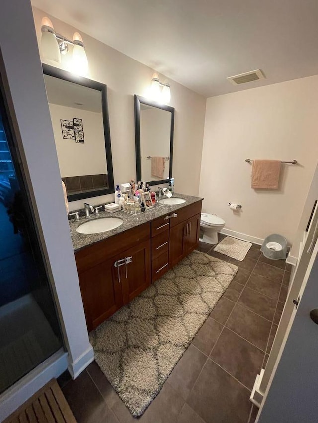 bathroom featuring tile patterned floors, vanity, and toilet