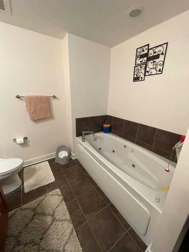 bathroom featuring tile patterned flooring, toilet, and a bathing tub