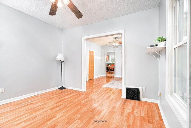 unfurnished room with a textured ceiling, light hardwood / wood-style floors, and a healthy amount of sunlight