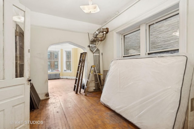 bedroom with radiator heating unit and dark wood-type flooring