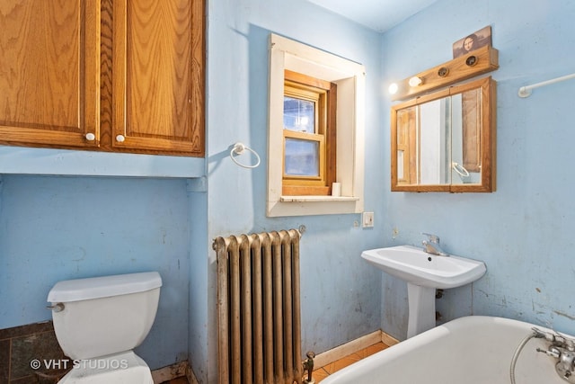 bathroom with radiator, a bathtub, and toilet